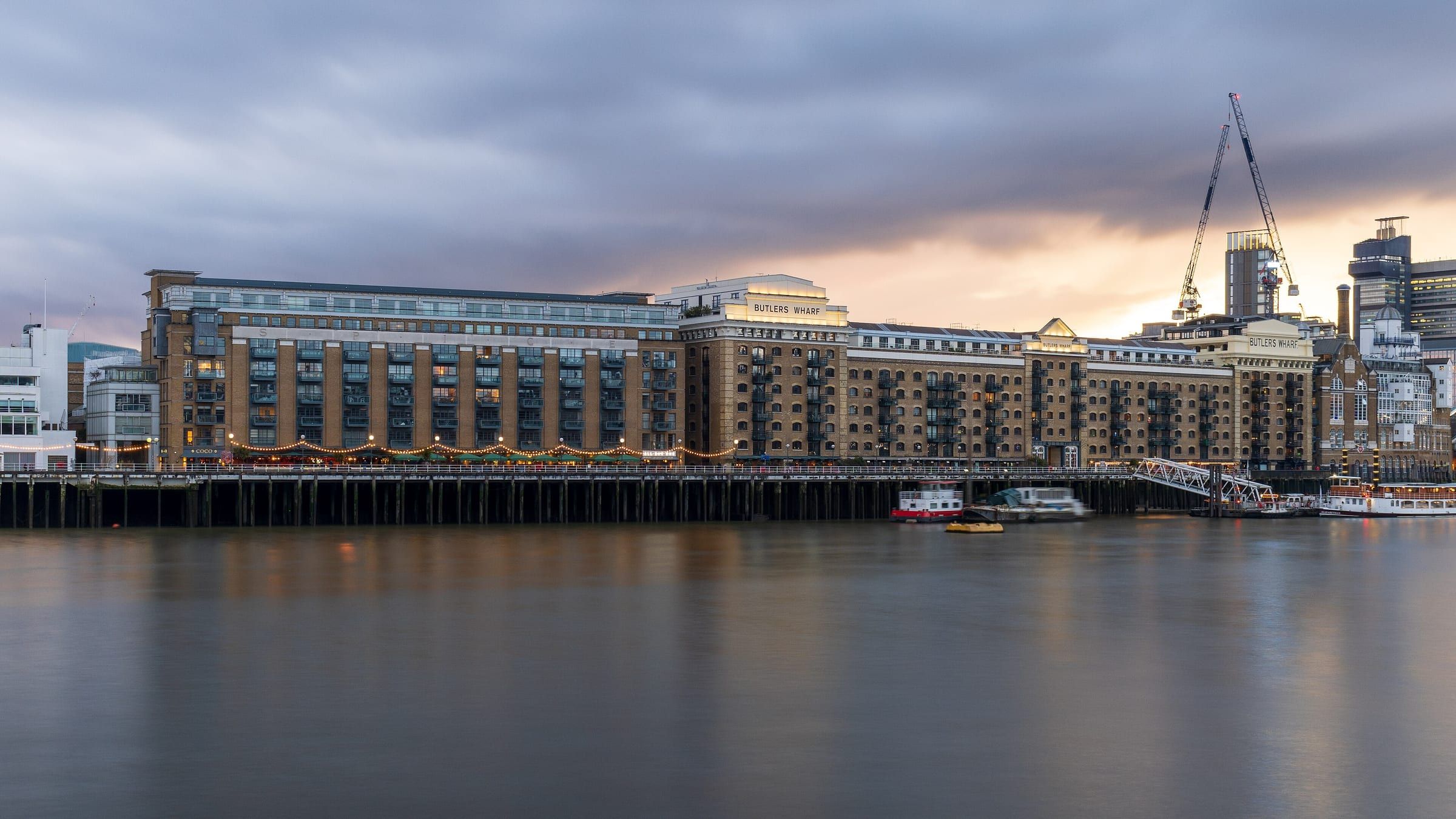 Butler’s Wharf warehouse apartments along the Thames under an evening sky